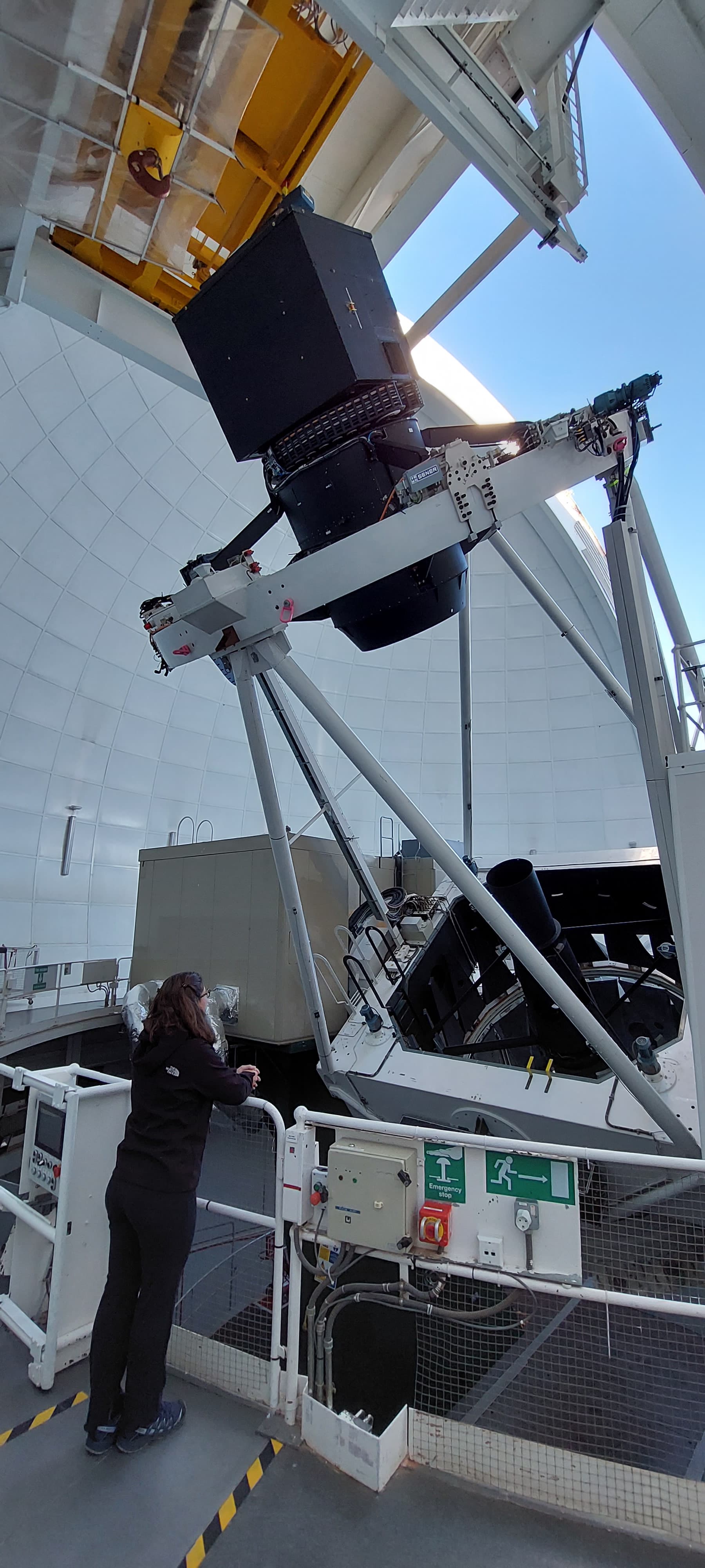 ING student looking at the WHT telescope with the WEAVE Positioner on the top.